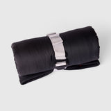 A My Place dog bed rolled up and closed with a g hook on a light grey background